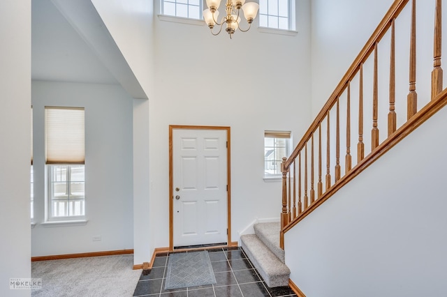 carpeted foyer with an inviting chandelier and a towering ceiling