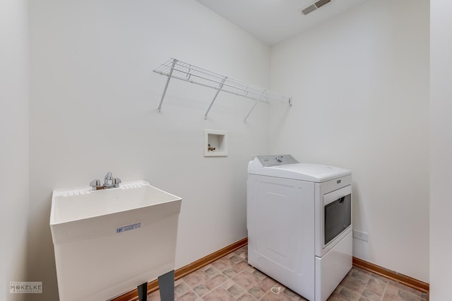 clothes washing area featuring washer / clothes dryer and sink