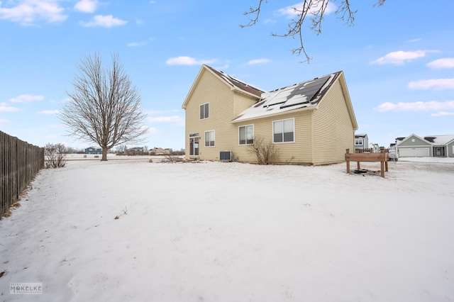 snow covered property with central air condition unit