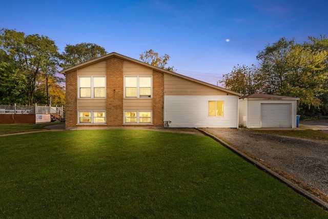 view of front of home with a garage, an outbuilding, and a lawn