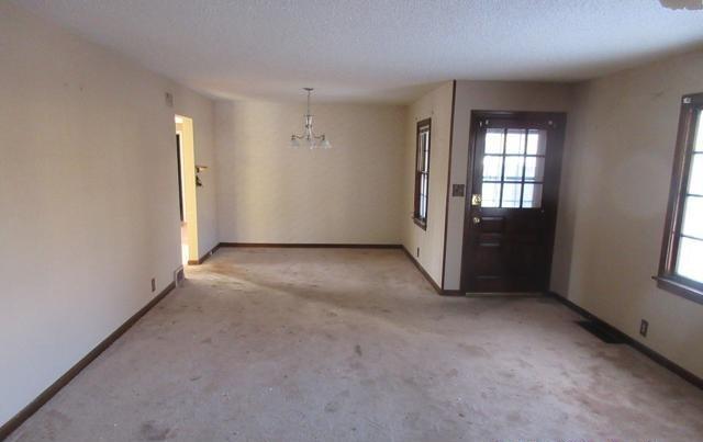 interior space with plenty of natural light, a chandelier, and a textured ceiling