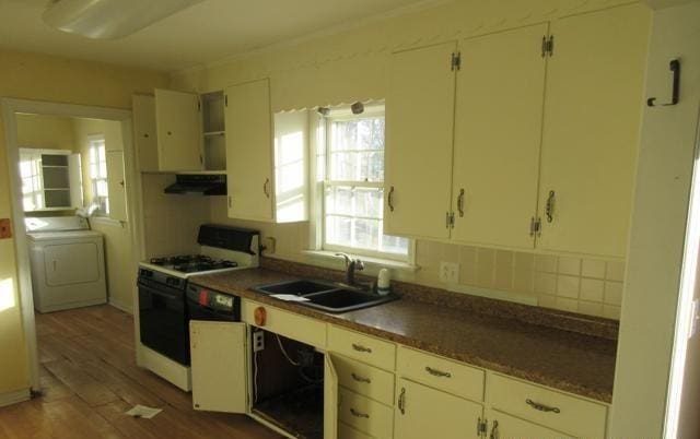 kitchen with sink, washer / dryer, dark wood-type flooring, and white range with gas stovetop