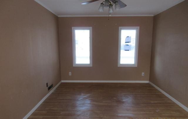 spare room featuring crown molding, dark wood-type flooring, and ceiling fan