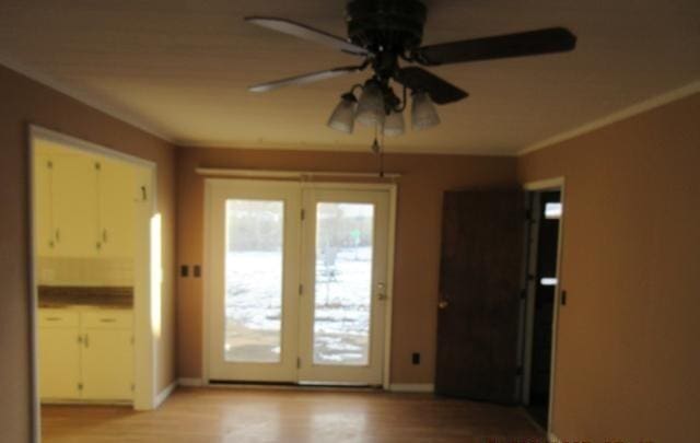 doorway to outside featuring crown molding, ceiling fan, and light hardwood / wood-style flooring