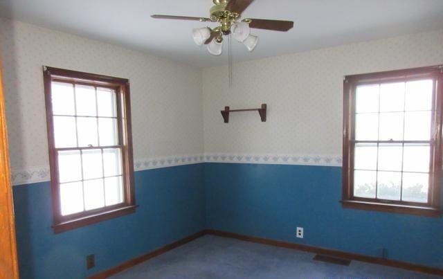 spare room featuring ceiling fan and a healthy amount of sunlight