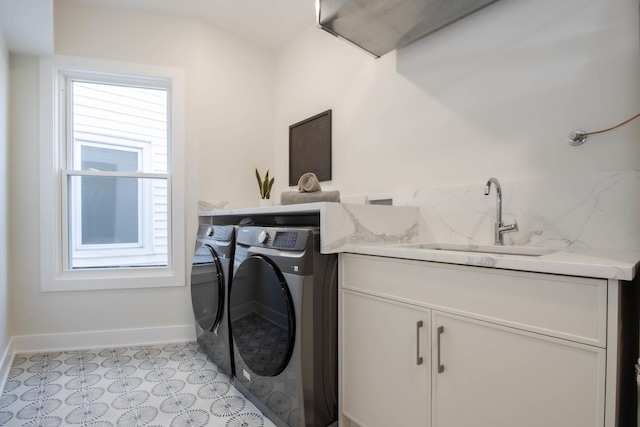 washroom featuring cabinets, washing machine and clothes dryer, sink, and light tile patterned floors