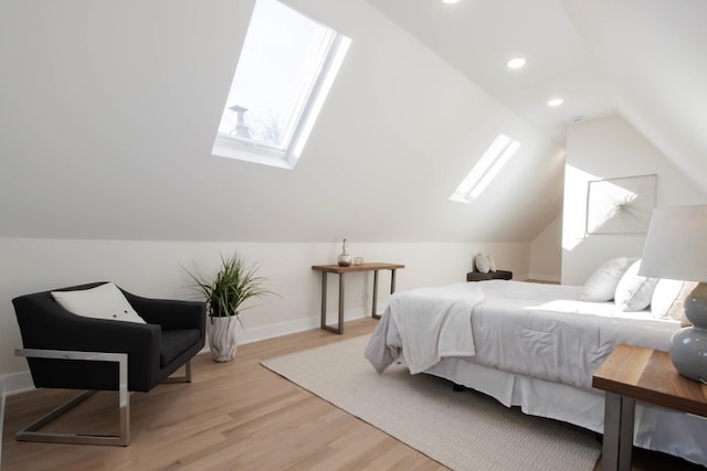 bedroom featuring multiple windows, vaulted ceiling with skylight, and light wood-type flooring