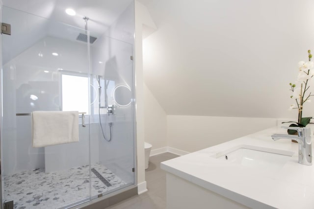 bathroom featuring lofted ceiling, vanity, and a shower with door