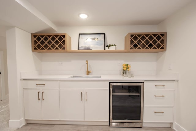 bar with wine cooler, sink, and white cabinets