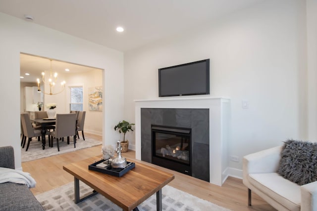 living room featuring hardwood / wood-style floors, a fireplace, and a chandelier