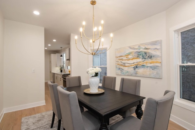 dining space with an inviting chandelier and light hardwood / wood-style flooring