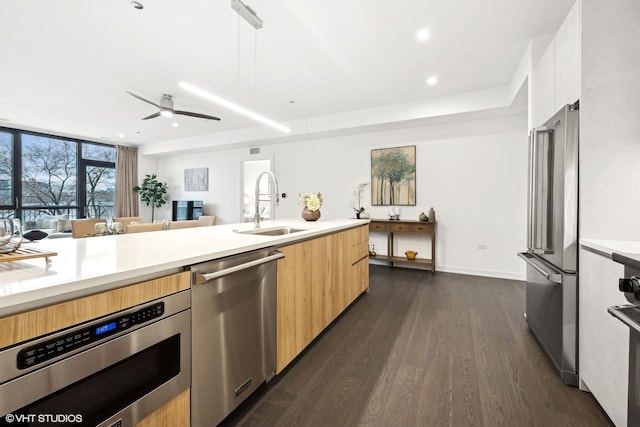 kitchen with pendant lighting, sink, dark hardwood / wood-style flooring, stainless steel appliances, and light brown cabinets