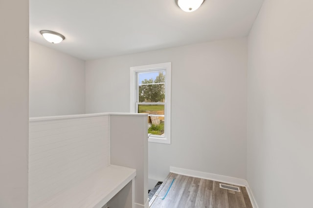 mudroom with baseboards, visible vents, and wood finished floors