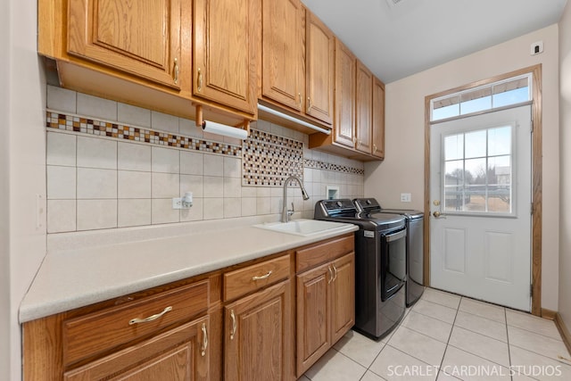 washroom featuring sink, light tile patterned floors, cabinets, and independent washer and dryer