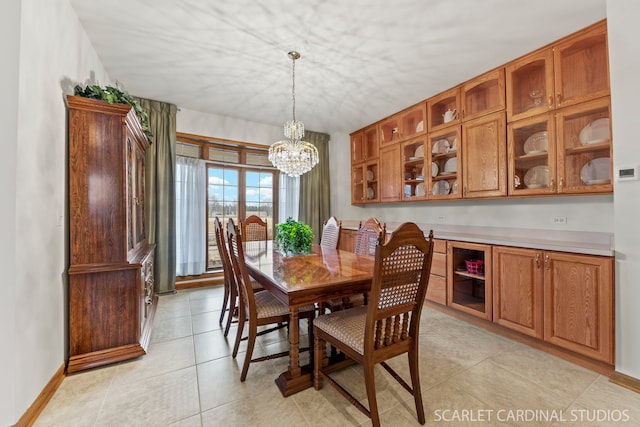 dining room with light tile patterned floors and a chandelier