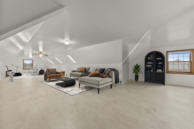 living room featuring ceiling fan and lofted ceiling with skylight