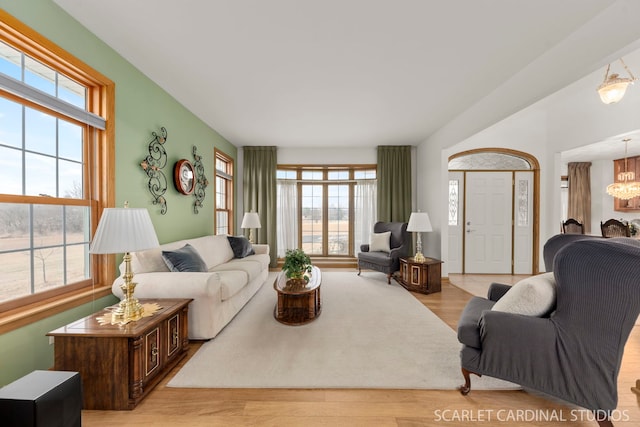 living room with an inviting chandelier and light wood-type flooring