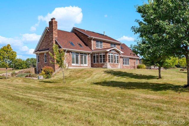 rear view of property featuring a lawn