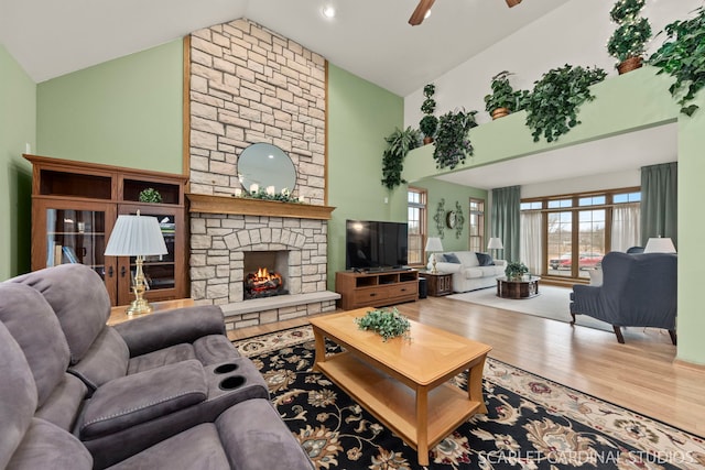 living room with ceiling fan, high vaulted ceiling, a fireplace, and hardwood / wood-style floors