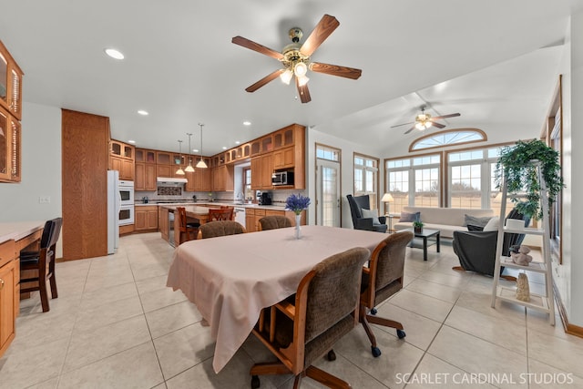 tiled dining area featuring ceiling fan, lofted ceiling, and a healthy amount of sunlight