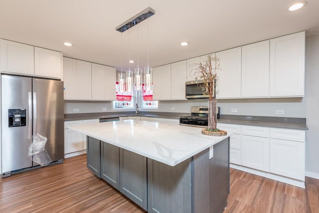 kitchen featuring white cabinetry, sink, stainless steel appliances, and a center island