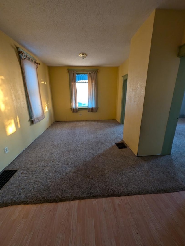 unfurnished room featuring hardwood / wood-style floors and a textured ceiling