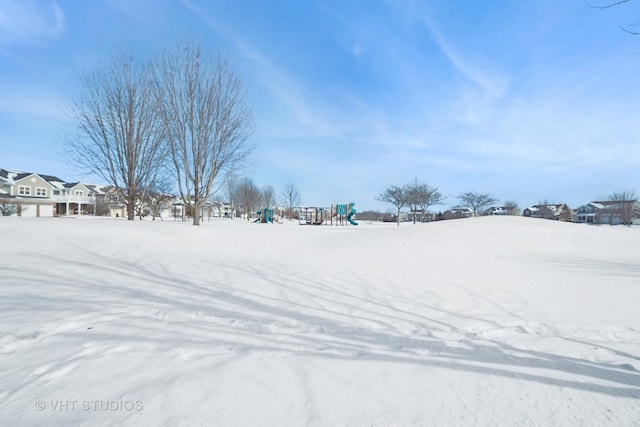 yard covered in snow with a playground