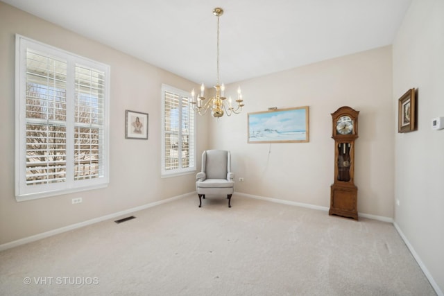 sitting room featuring light carpet and a notable chandelier