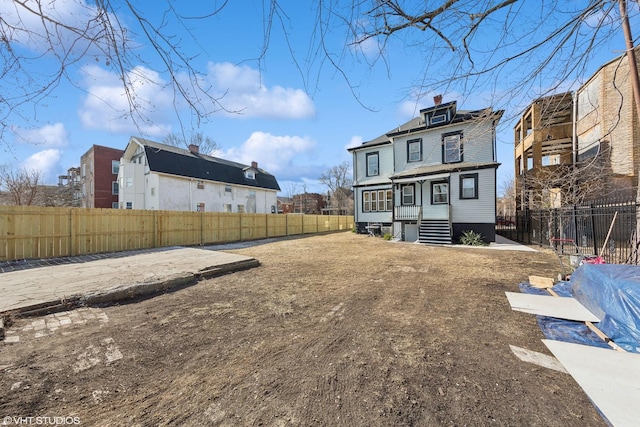7121 S Yale Ave, Chicago, IL 60621 - rear view of house with a fenced backyard, a chimney, and a residential view