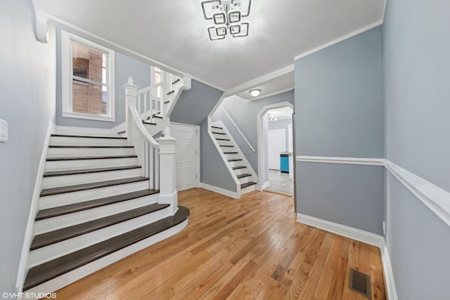 stairway featuring ornamental molding and hardwood / wood-style floors