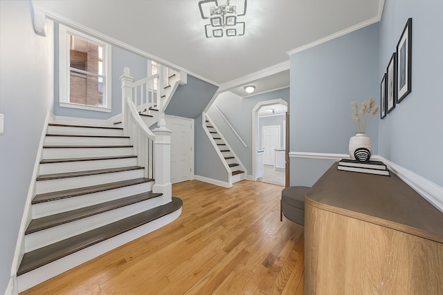 7121 S Yale Ave, Chicago, IL 60621 - entryway featuring stairs, light wood-style floors, ornamental molding, and arched walkways
