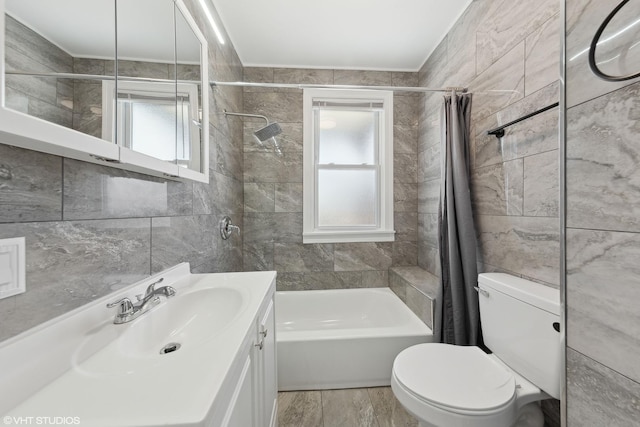 full bathroom featuring tile walls, shower / tub combo, hardwood / wood-style floors, vanity, and toilet