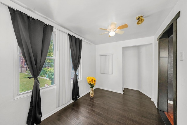 empty room featuring dark wood-type flooring and ceiling fan