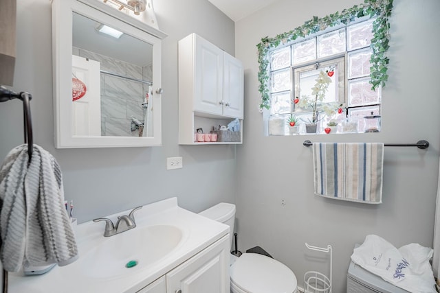 bathroom featuring vanity, toilet, and walk in shower