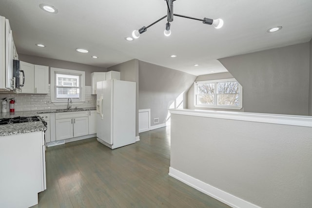 kitchen featuring sink, white cabinets, dark hardwood / wood-style flooring, white refrigerator with ice dispenser, and light stone counters