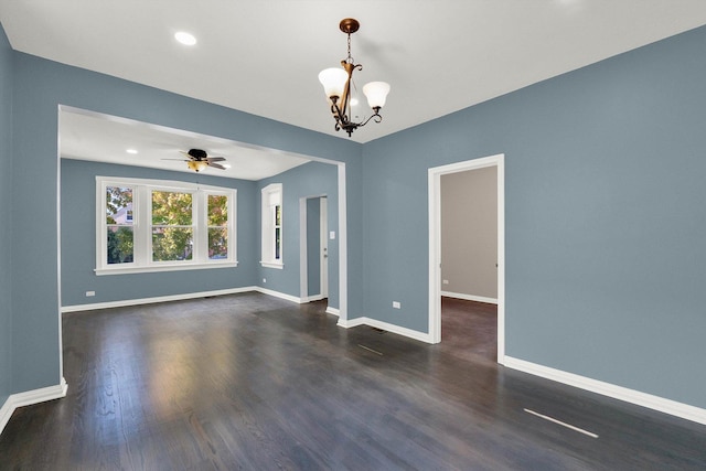 unfurnished room featuring ceiling fan with notable chandelier and dark wood-type flooring