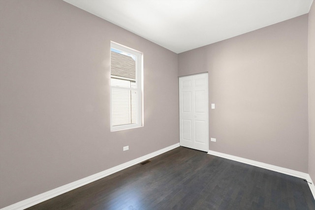 empty room with dark hardwood / wood-style flooring