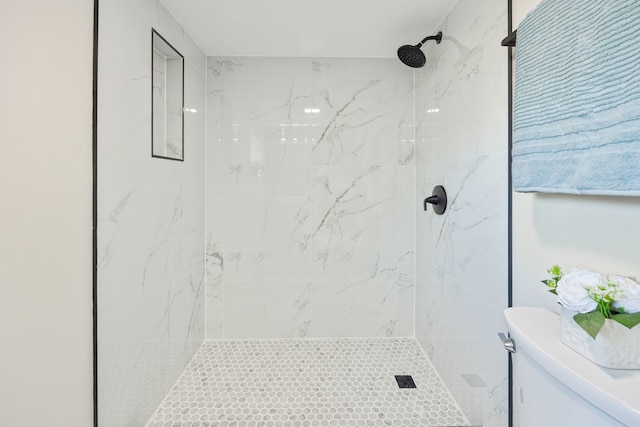 bathroom with toilet and tiled shower