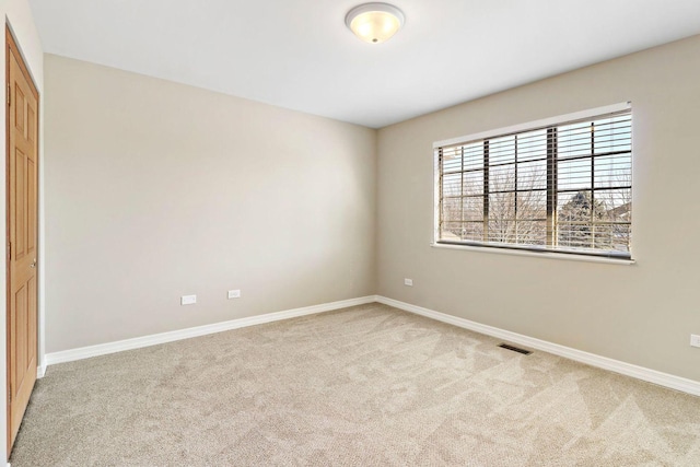 carpeted spare room with baseboards and visible vents