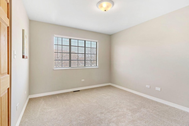 unfurnished room with visible vents, baseboards, and carpet flooring