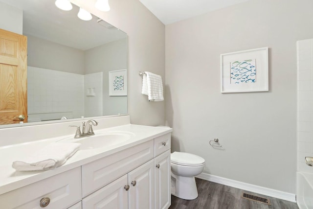 bathroom featuring vanity, wood finished floors, visible vents, baseboards, and toilet