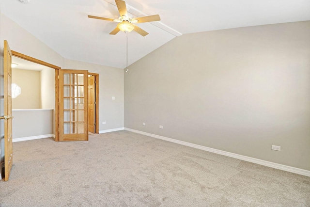 carpeted empty room featuring lofted ceiling, a ceiling fan, baseboards, and french doors