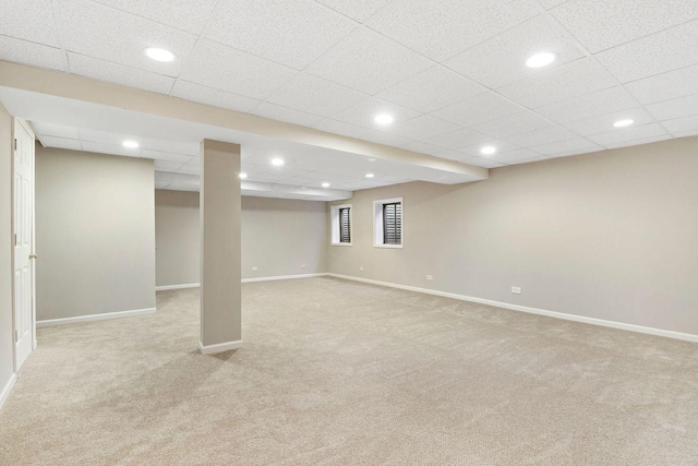 basement featuring light colored carpet, recessed lighting, baseboards, and a paneled ceiling