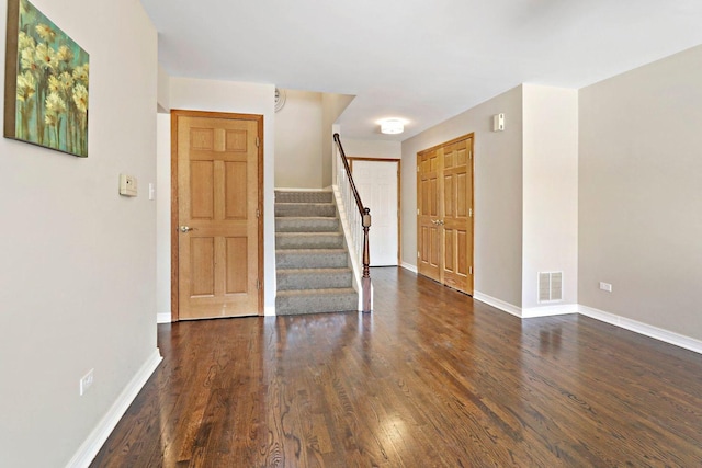 entryway featuring stairway, wood finished floors, visible vents, and baseboards