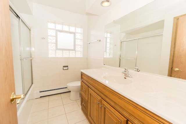 full bathroom featuring tile walls, a baseboard heating unit, vanity, tile patterned floors, and toilet