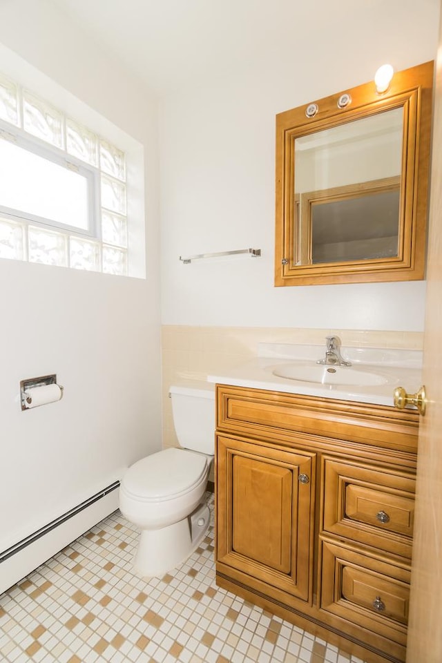 bathroom with vanity, a baseboard heating unit, and toilet