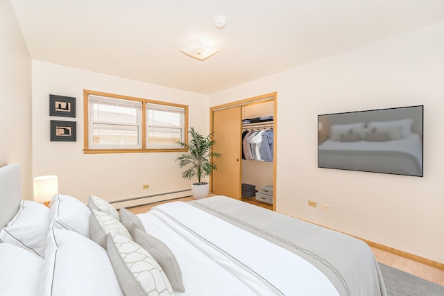 bedroom with carpet flooring, a closet, and a baseboard heating unit