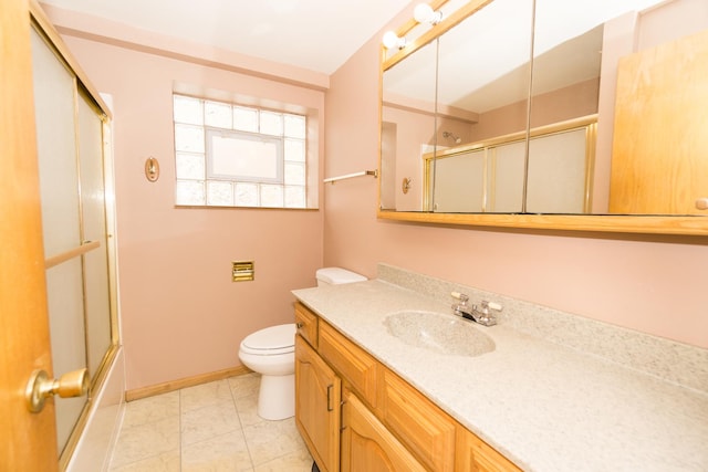 full bathroom featuring tile patterned flooring, vanity, bath / shower combo with glass door, and toilet