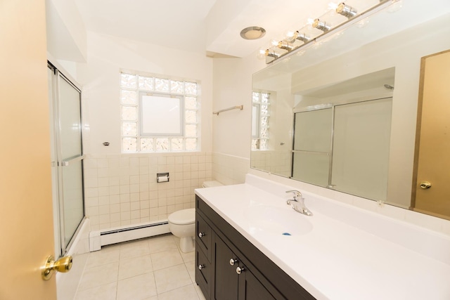 full bathroom with tile patterned floors, toilet, tile walls, baseboard heating, and vanity