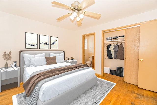 bedroom with hardwood / wood-style flooring, ensuite bath, ceiling fan, and a closet